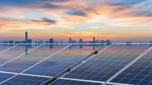 Solar panels with a city skyline in the distance