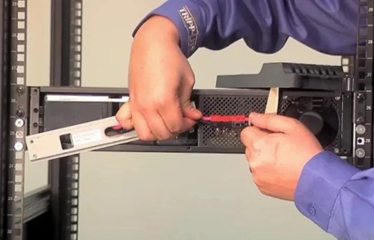 Technician replacing a battery in a rack-mounted UPS